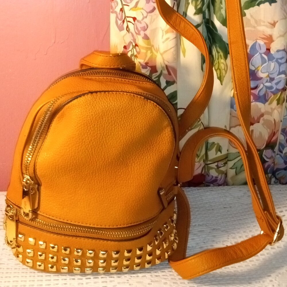 BROWN MINI BACKPACK TRIMMED IN GOLD DECOR WITH ZIPPERS.